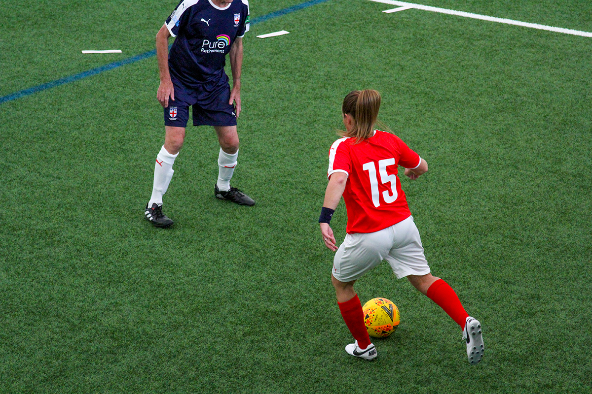 A walking football match seen from above on an indoor pitch
